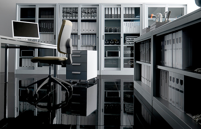 Ufficio moderno con scrivania, sedia ergonomica, scaffali pieni di documenti e pavimento riflettente nero.
